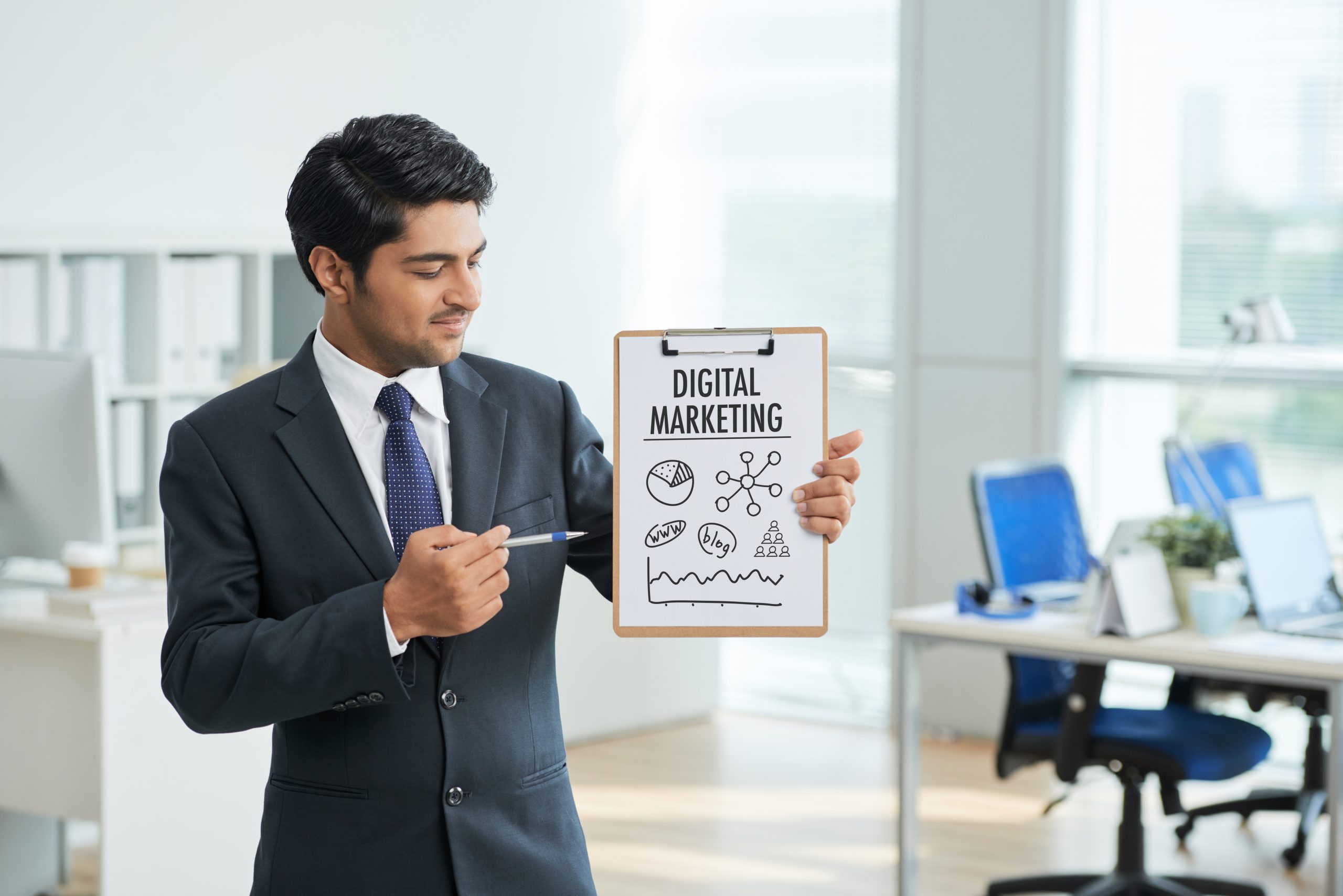 man suit standing office with clipboard pointing poster with words scaled